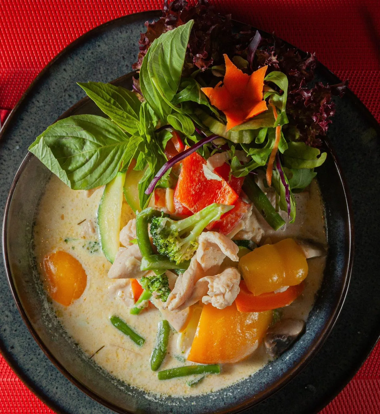 Grünes Thai-Curry mit Hühnchen, Gemüse und frischem Basilikum